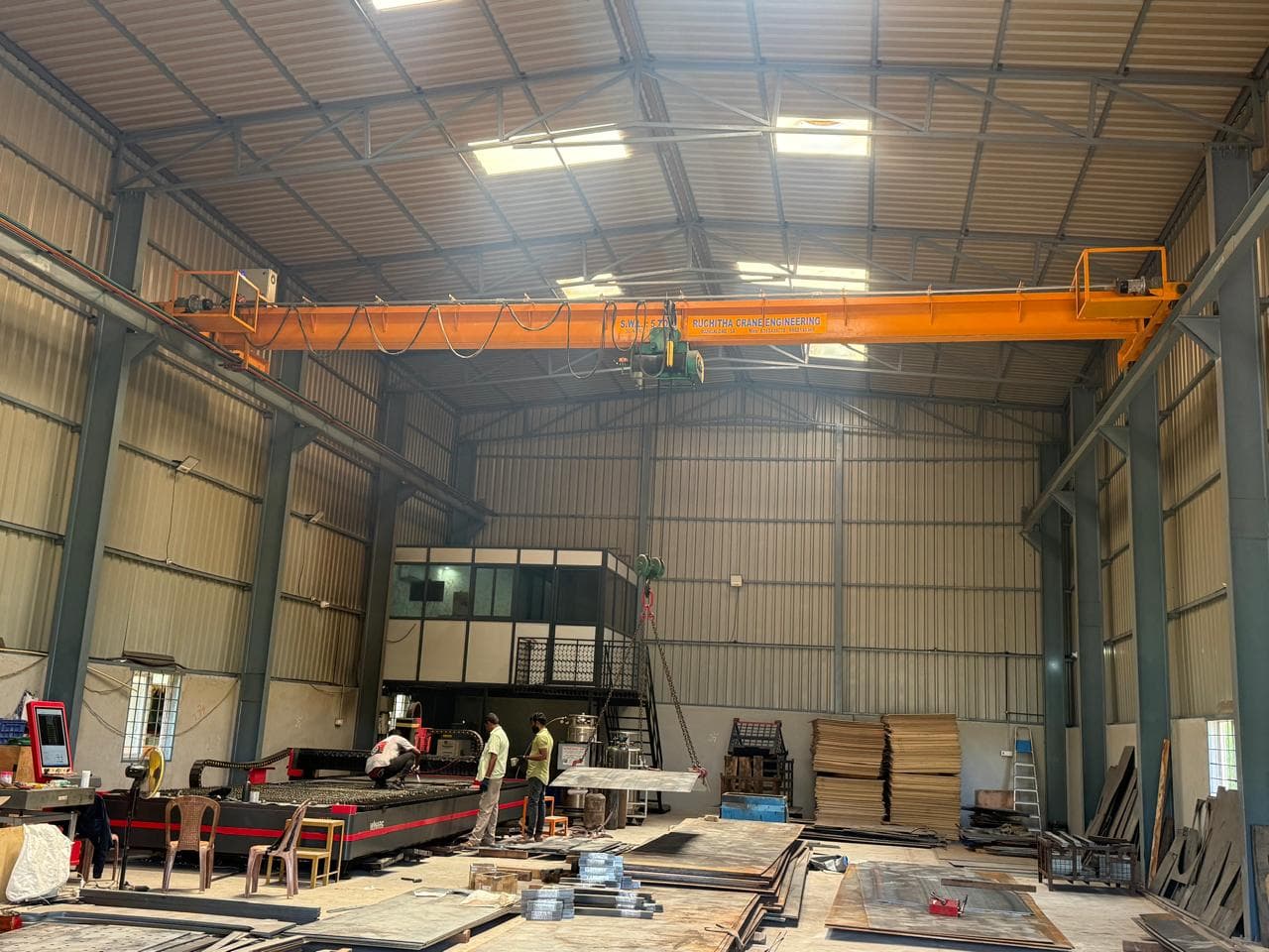 Global Laser Solutions factory interior showing EOT crane, laser cutting machine and workers
