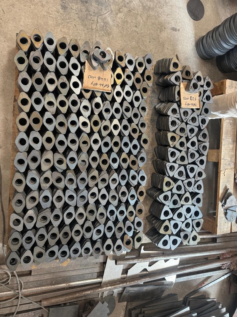 Batch of precision laser cut capsule-shaped metal parts stacked on pallet